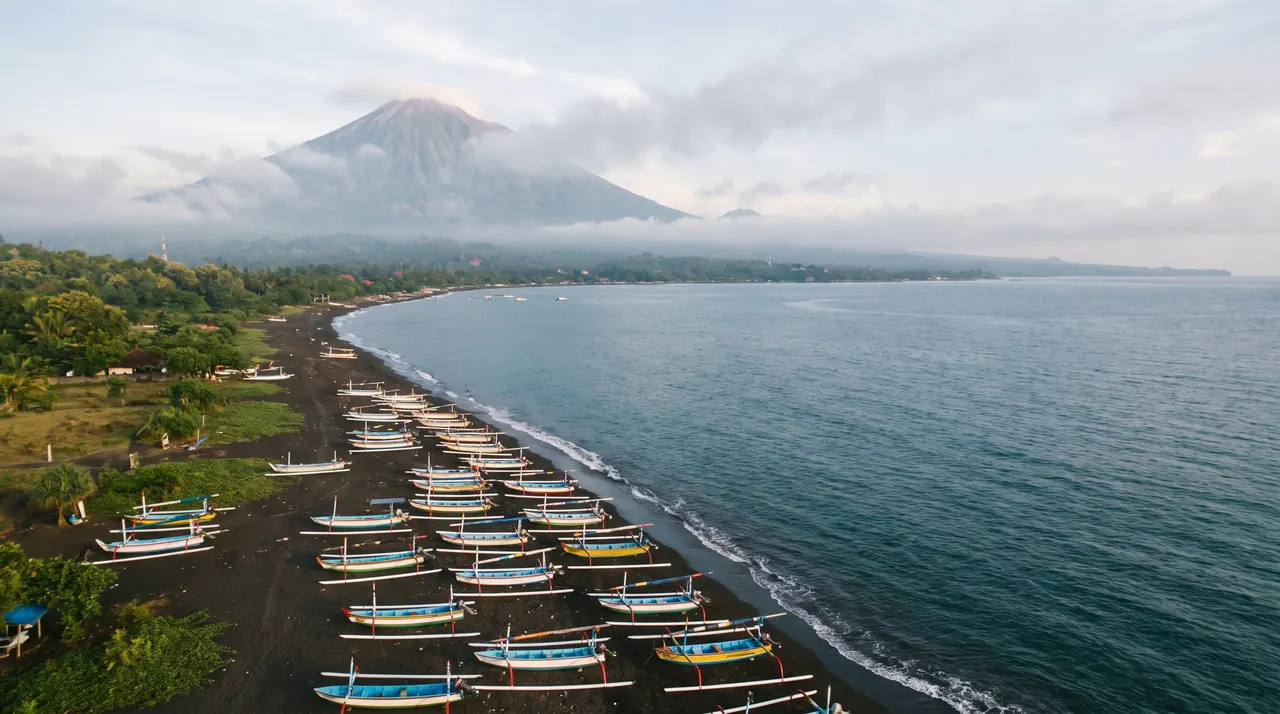 Amed coast in east Bali with Mount Agung behind, from a helicopter
