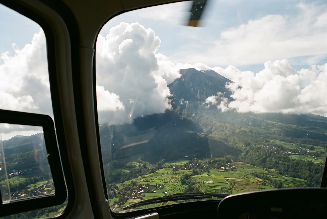 Clouds building around Mount Agung seen through a helicopter window in Bali