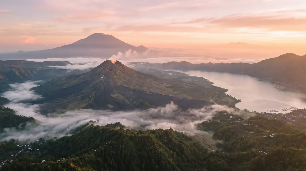 Mount Batur caldera and lake at sunrise from a helicopter in Bali