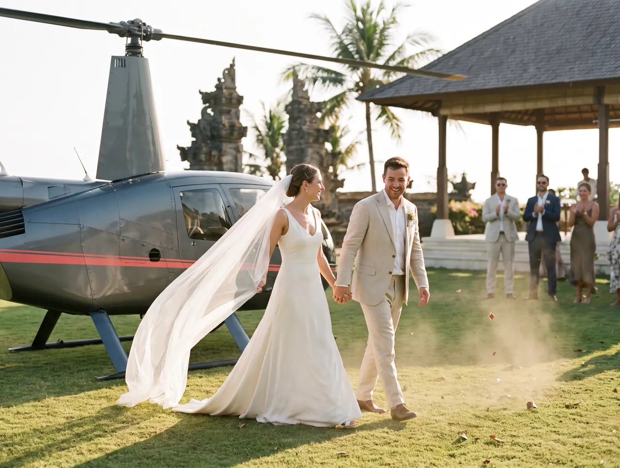 Bride and groom walking from a helicopter across the lawn of a Bali villa